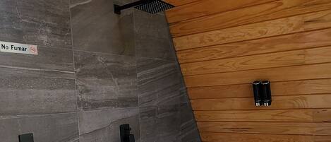 A modern bathroom with a large bathtub, wooden ceiling, and a sign indicating no fumigation.
