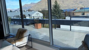 Quarto moderno com amplas janelas e vista para as montanhas.