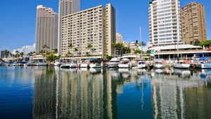 Una marina con diverse imbarcazioni ormeggiate, circondata da edifici alti.