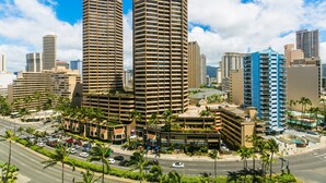 A high-rise building with a modern architectural design, featuring a prominent central tower and surrounding structures. - Nicely Appointed One Bedroom! City Lights and Mountain Views! (Honolulu)