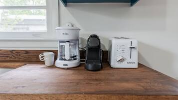 A kitchen counter with a coffee maker, a toaster, and a mug.