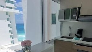 Una cucina moderna con un'ampia finestra, un lavello, un forno a microonde e una macchina del caffè.