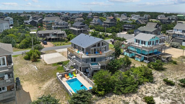 A residential area with a house featuring a large deck and a swimming pool.