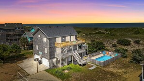 A two-story house with a balcony and a swimming pool.