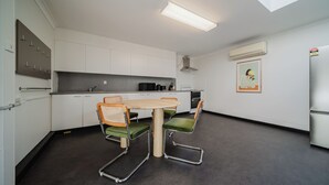 Een moderne keuken met een eettafel, stoelen en een koelkast.