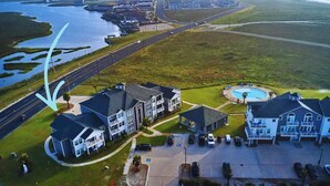 A residential area with houses, a swimming pool, and a road. - Walk to the Beach- Peaceful and Modern Condo (Corpus Christi)