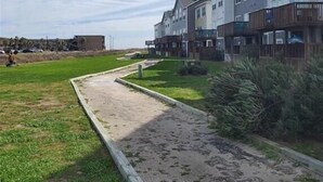 A residential area with a pathway leading to a row of houses. - Walk to the Beach- Peaceful and Modern Condo (Corpus Christi)