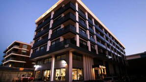 A multi-story hotel with a modern design, featuring balconies and large windows. - Krem Marin Suits Otel (Cesme)