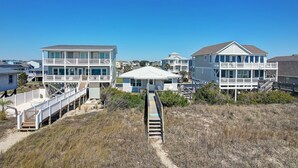 A coastal residential area with houses featuring balconies and a pathway leading to the beach. - "Lifesaver" is a 2 Bedroom, 1 Bathroom, Oceanfront Home! (Holden Beach)