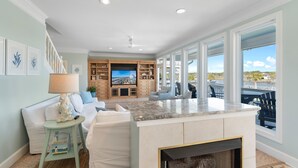 A spacious living area with a large window, a fireplace, and a TV.