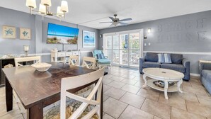 A spacious living area with a dining table, a sofa, and a ceiling fan. - Southbay by the Gulf 78, three hundred yards from the beach (Destin)
