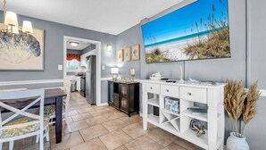A modern kitchen with a dining area, a large flat-screen TV, and a view of the beach. - Southbay by the Gulf 78, three hundred yards from the beach (Destin)