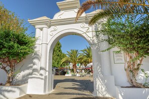 Stunning archway entrance with intricate carvings and decorative details, set amidst lush greenery.
