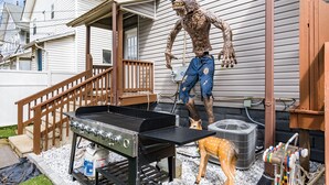 Un jardin avec un barbecue, une statue de cerf et une grande statue de loup.