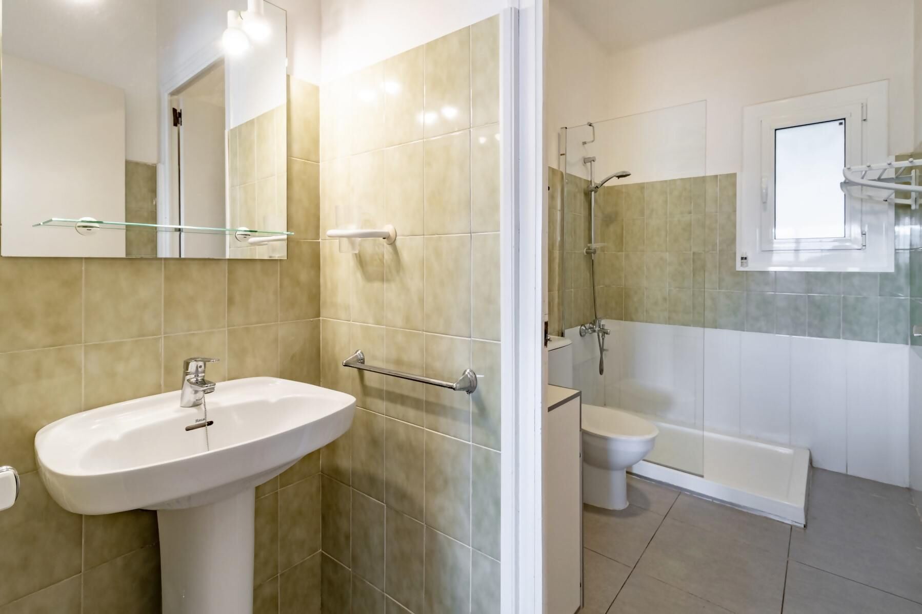 Et moderne badeværelse med vask, toilet og bruseområde.