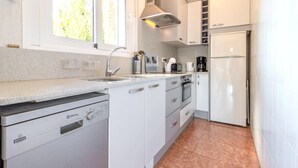 A compact kitchen with a dishwasher, oven, and refrigerator. - Cap Ras 04.3 - Apartment with terrace and sea view (Llança)