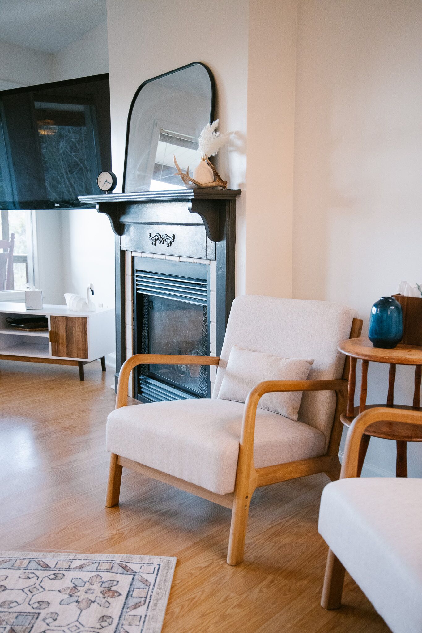 Ein modernes Wohnzimmer mit Kamin, einer Couch, einem Holztisch und einem Beistelltisch.