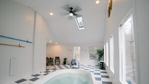 An indoor swimming pool with a checkered floor, a ceiling fan, and large windows. - Hickory Hill Round House: Indoor POOL, mins from South Holston River, with view  (Bluff City)