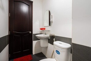 Bathroom features a white sink, toilet, and a two-tone tile wall.