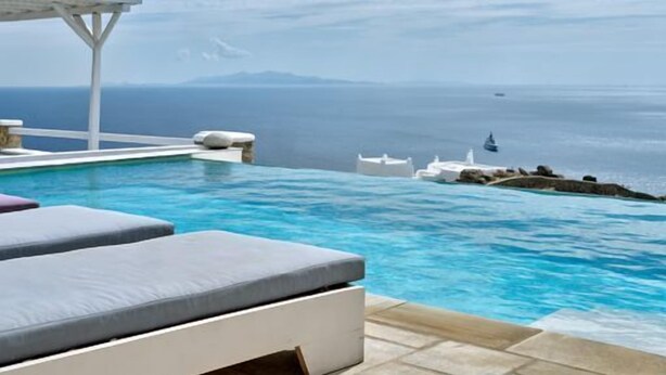 Ein Infinity-Pool mit freiem Blick auf das Meer und entfernte Inseln.