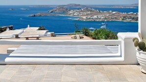 Eine Terrasse mit Blick auf das Meer und die felsige Küste.