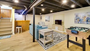 Un salon moderne avec un canapé, une table basse et une table de baby-foot.