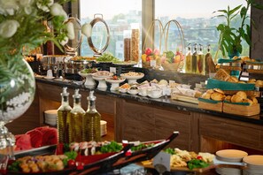 A buffet with various food items and condiments. - CLASSYC Hotel (Hanoi)