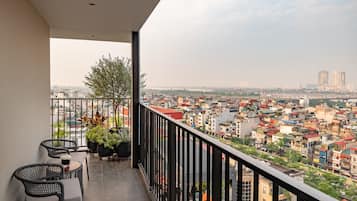 A balcony with a view of a cityscape, including buildings and a bridge.