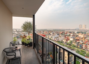 Un balcón con vistas a un paisaje urbano, que incluye edificios y un puente.