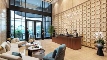 A hotel lobby with a reception desk, seating area, and large windows.