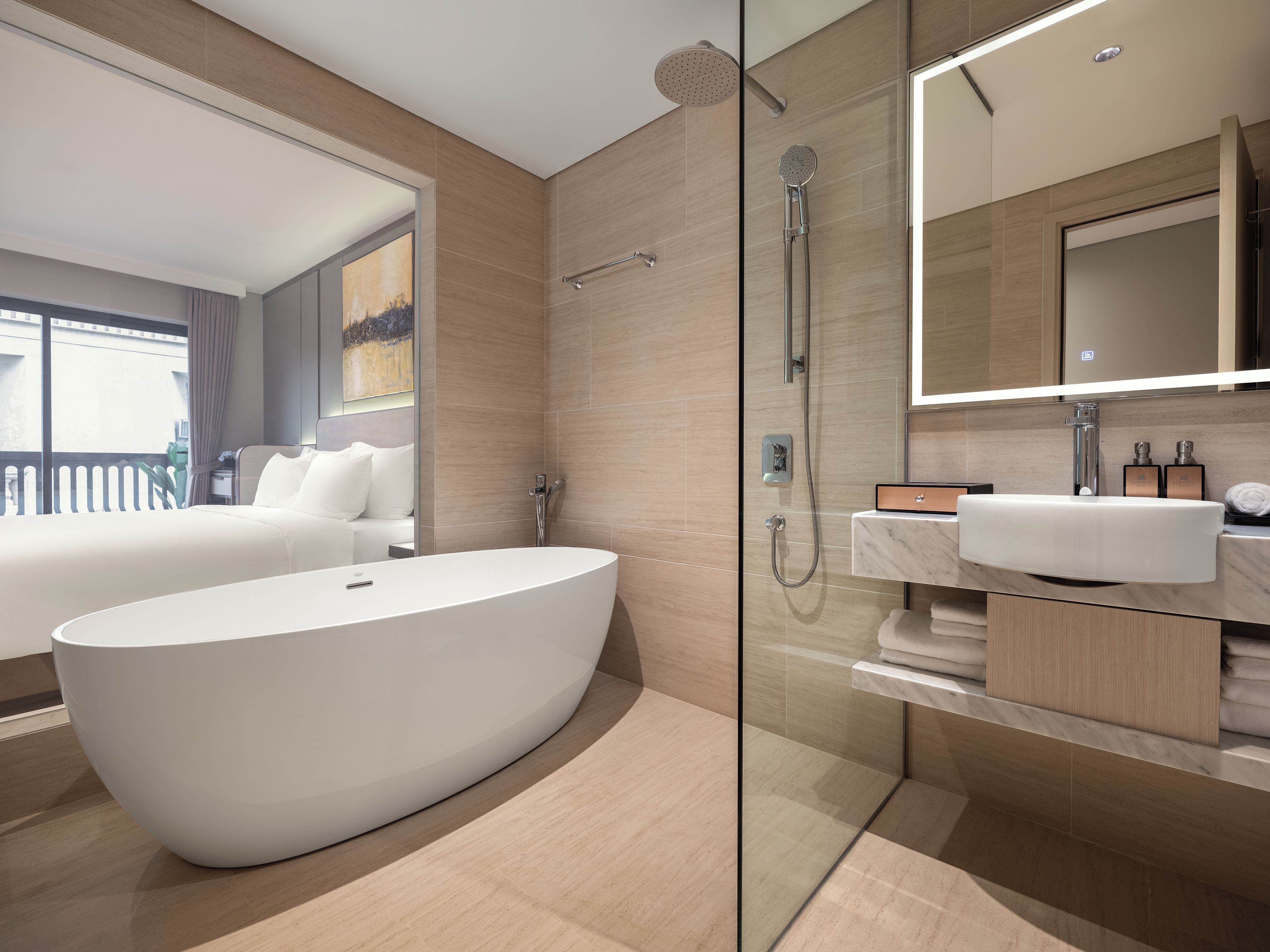 A modern bathroom with a freestanding bathtub, a glass-enclosed shower, and a marble vanity.