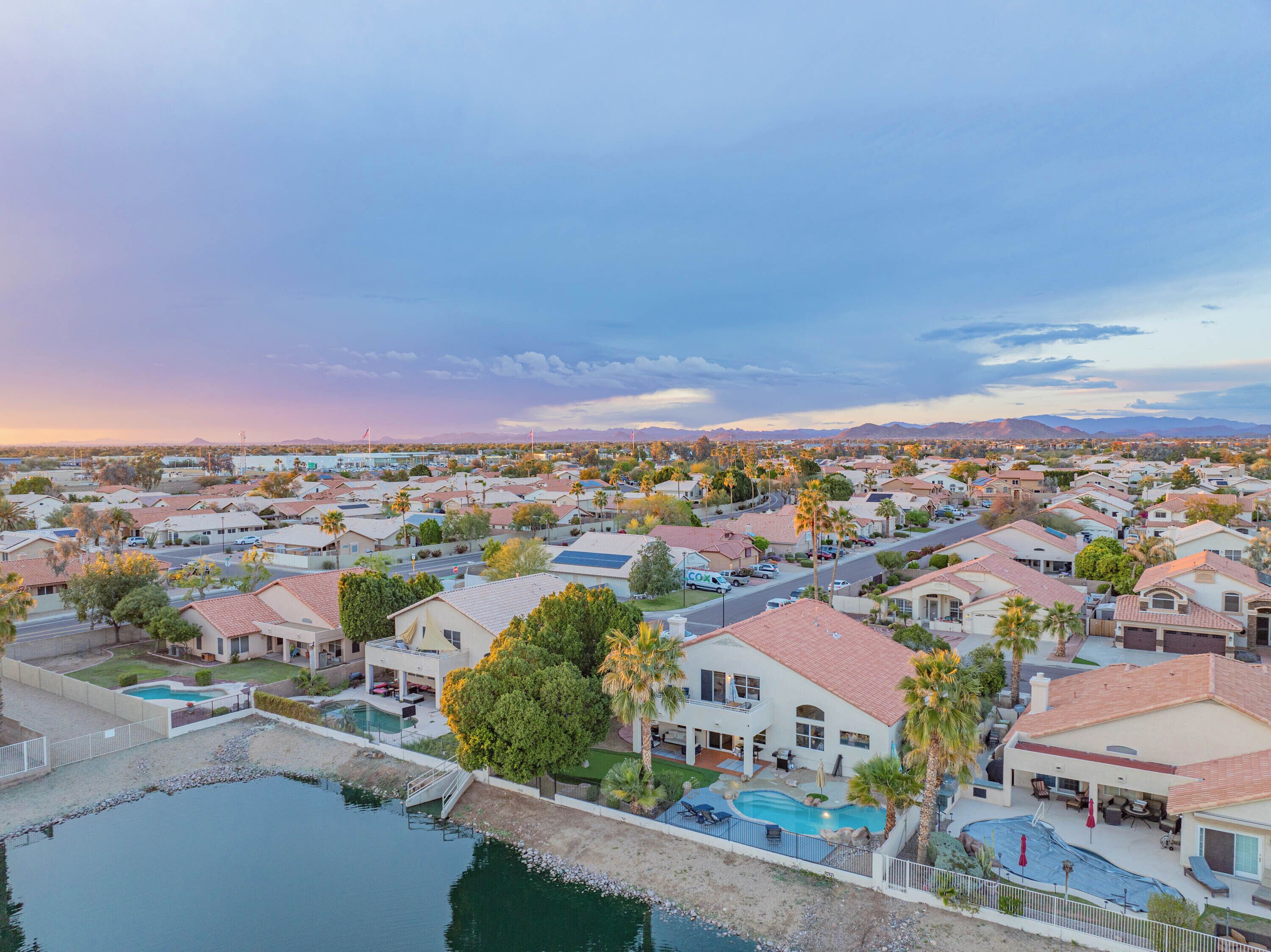 Un barrio residencial con casas, piscina y cielo despejado.