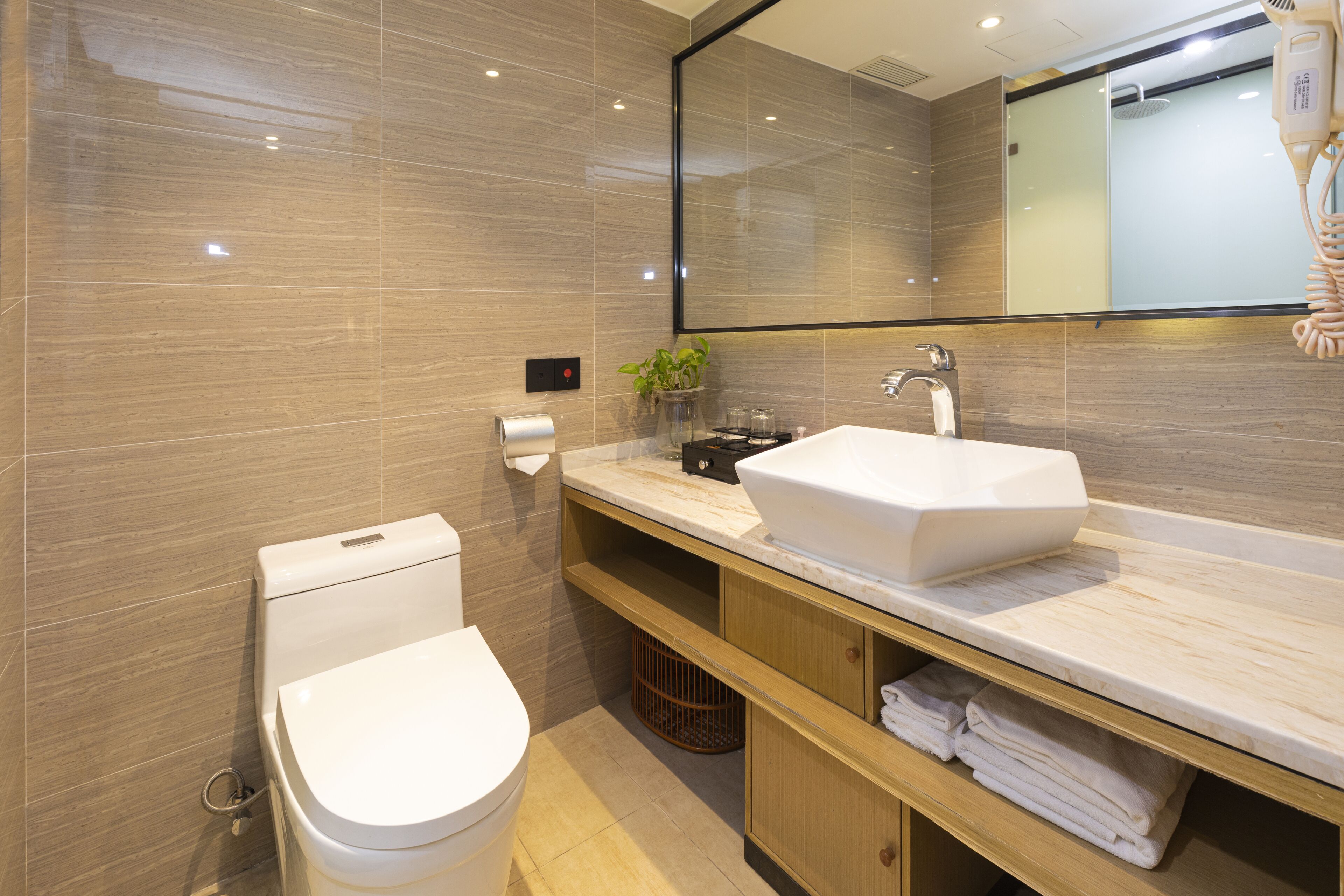 A modern bathroom with a toilet, sink, and mirror.