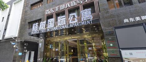 An international apartment building with a modern facade, large glass windows, and a visible entrance.