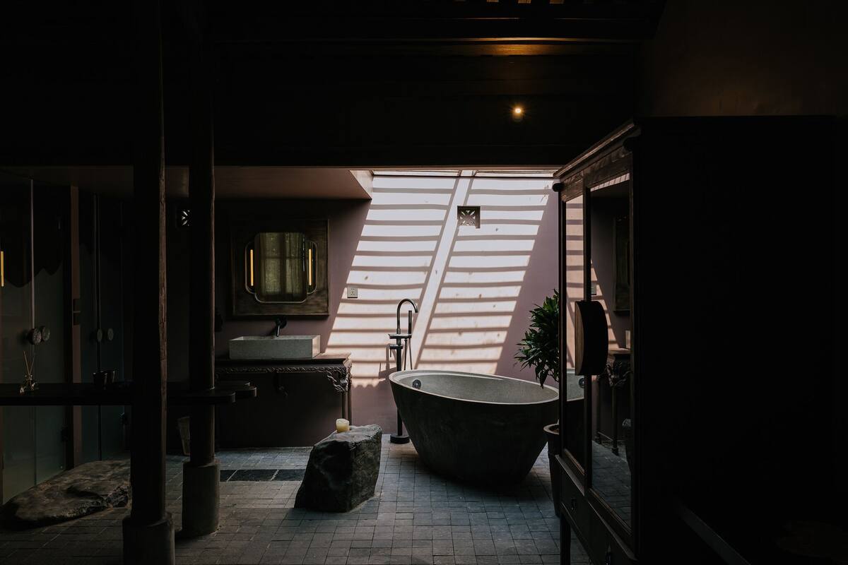 A modern bathroom with a freestanding bathtub, a sink, and a mirror.