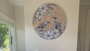 Un sillón púrpura con patas de madera en una habitación con pared blanca y ventana.