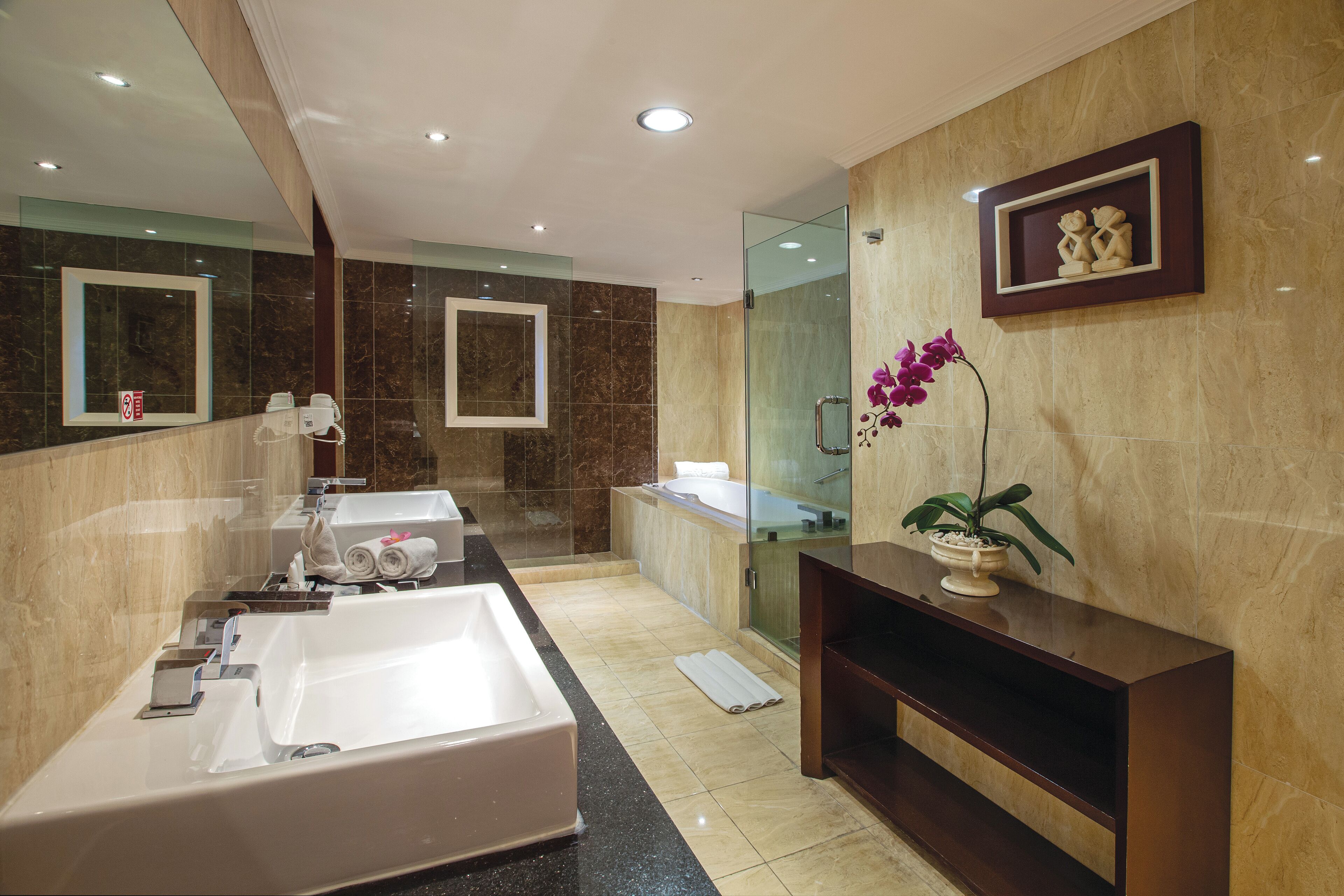 A modern bathroom with a large bathtub, a glass shower enclosure, and a vanity with a mirror.