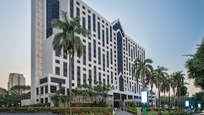 Un hotel moderno con fachada simétrica, varios pisos y una entrada central.