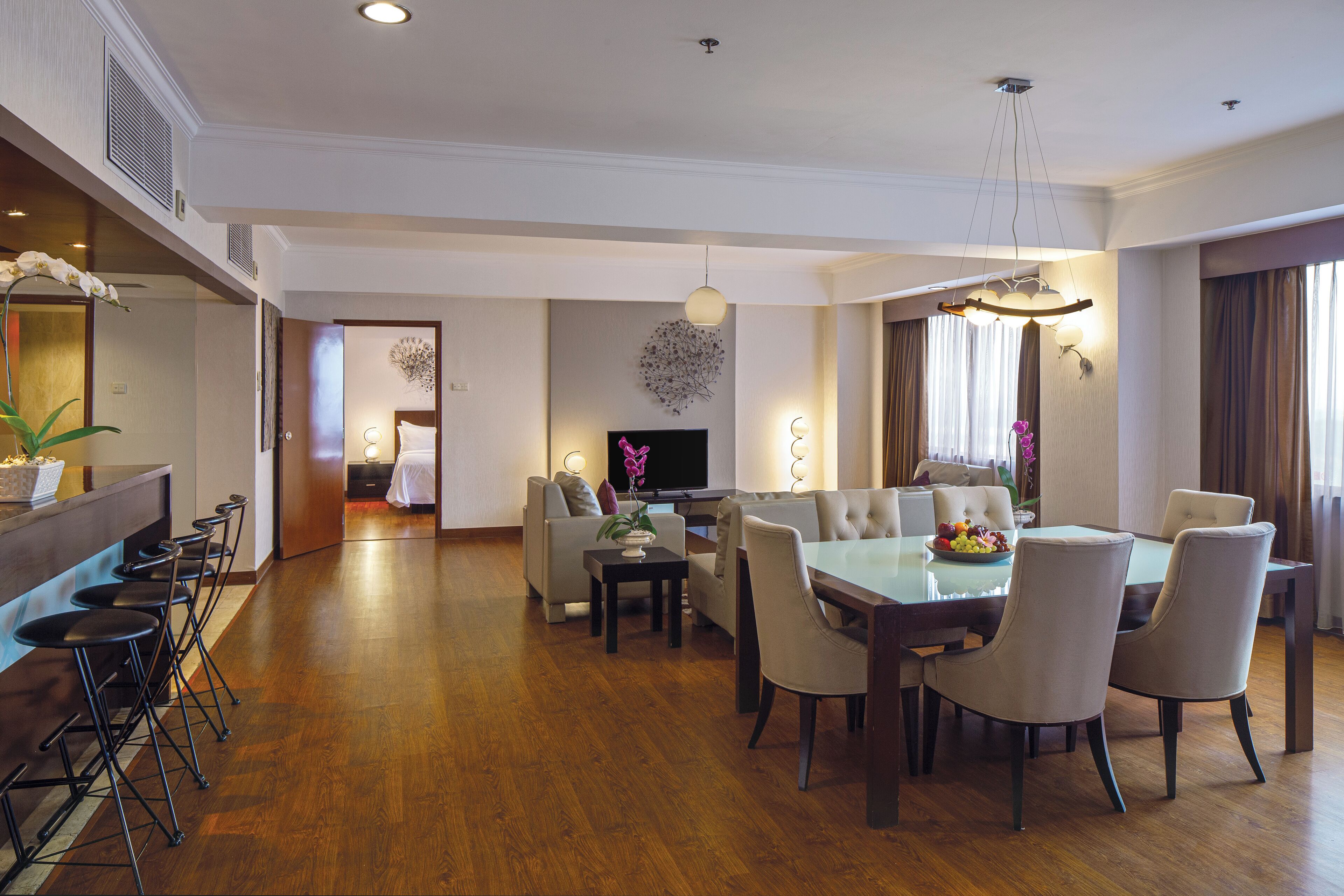 Ein geräumiges Hotelzimmer mit Essbereich, Wohnbereich und Bar.