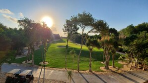 Un parcours de golf avec un chemin bien défini, des arbres et un chariot de golf.
