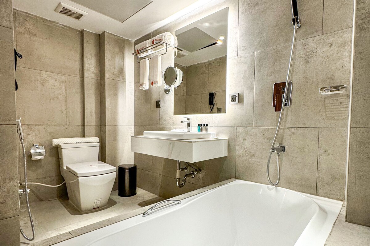 Ein modernes Badezimmer mit einer Badewanne, Toilette und Waschbecken.
