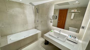 A modern bathroom with a bathtub, a sink, and a large mirror.