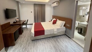 A modern hotel room with a bed, desk, chair, and a television. - Hotel omni residency Baridhara (Dhaka)