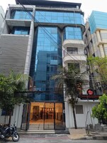 Un edificio moderno con fachada de vidrio, una entrada visible con portón metálico y un cartel que indica "OMNIRESDEN".