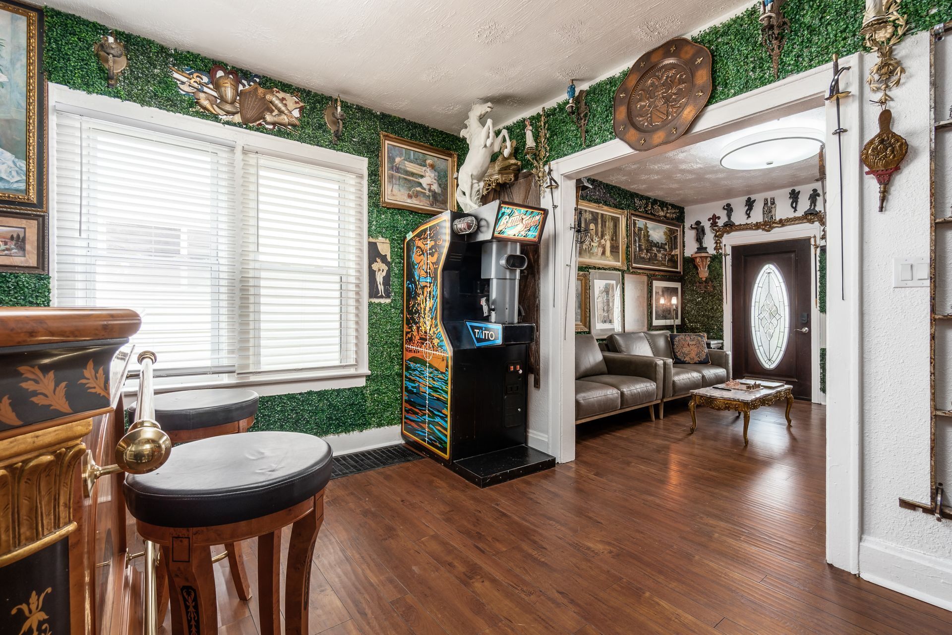 A room with a wooden floor, a sofa, a coffee table, and a jukebox.