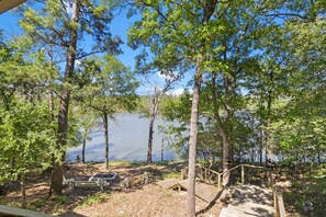 A lakeside campsite with wooden benches, a picnic table, and a wooden deck. - Waterfront Recreation Hideaway (Huntsville)