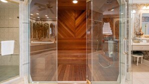 Une salle de bain moderne avec une douche à parois de verre, un plancher en bois et un mur recouvert de carreaux de marbre.