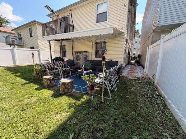 A backyard with a patio area, outdoor furniture, and a small pool. - Exquisite 3 Bedrooms (Newark)