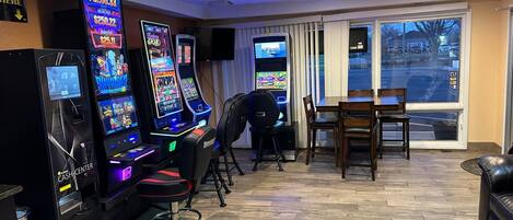 A room with gaming machines, a dining area, and a view of the street.