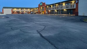 A large parking lot with a hotel building featuring multiple floors and a visible sign. - Stay Inn by OYO Near I 80 Lincoln West (Lincoln)